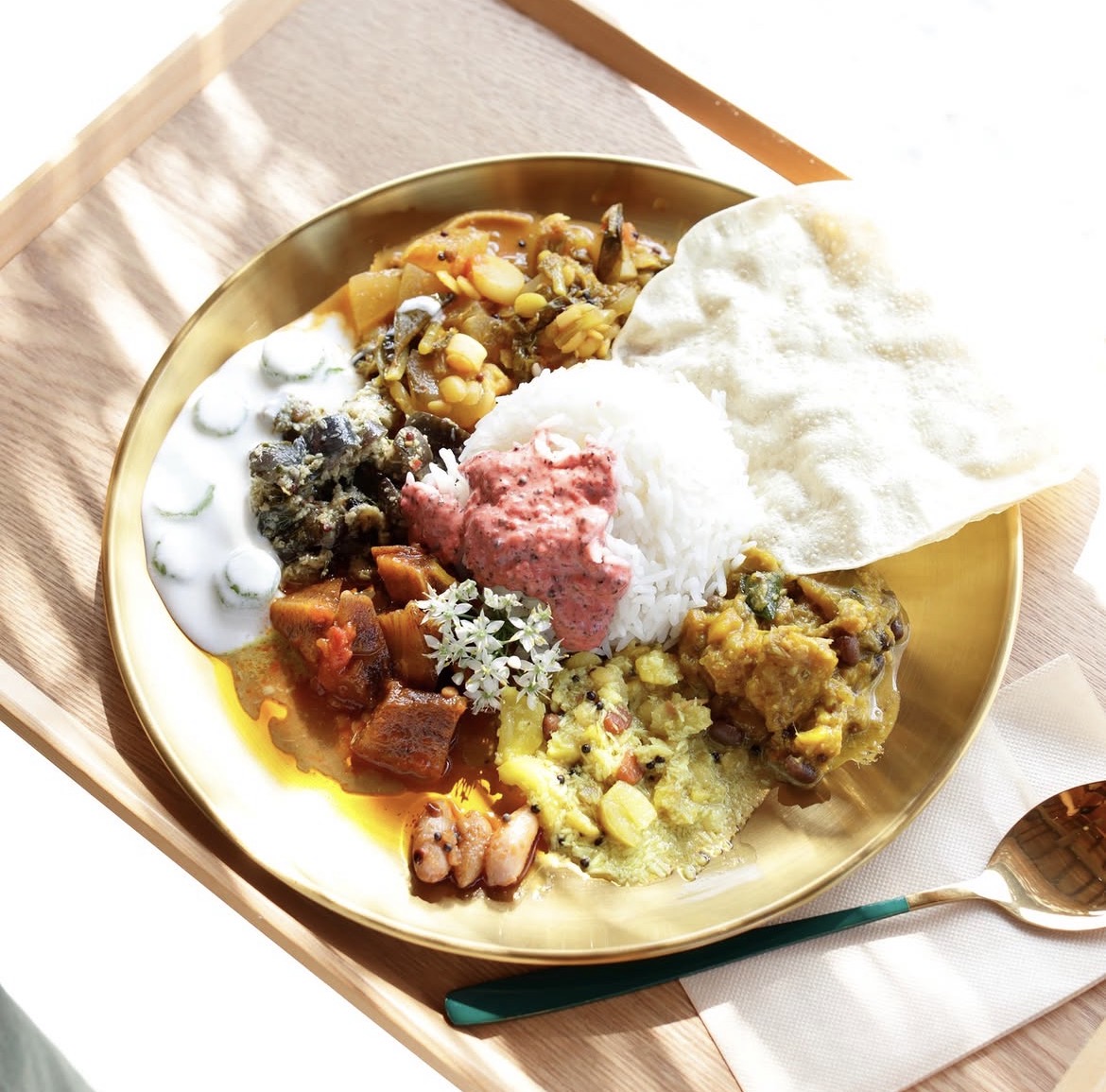 金色のお皿に盛り付けた色とりどりのスパイス料理